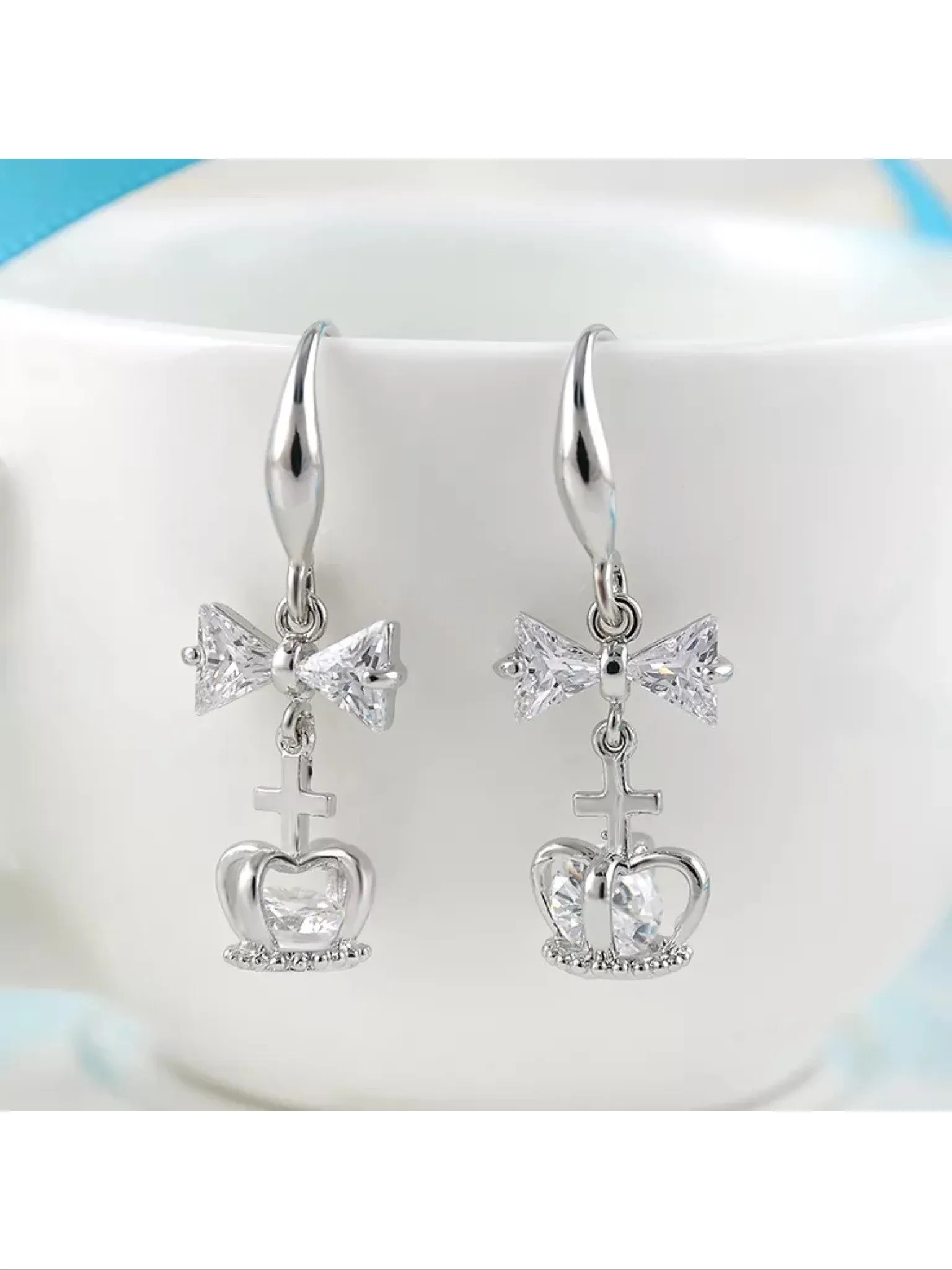 Silver plated bow and cross and crown earrings